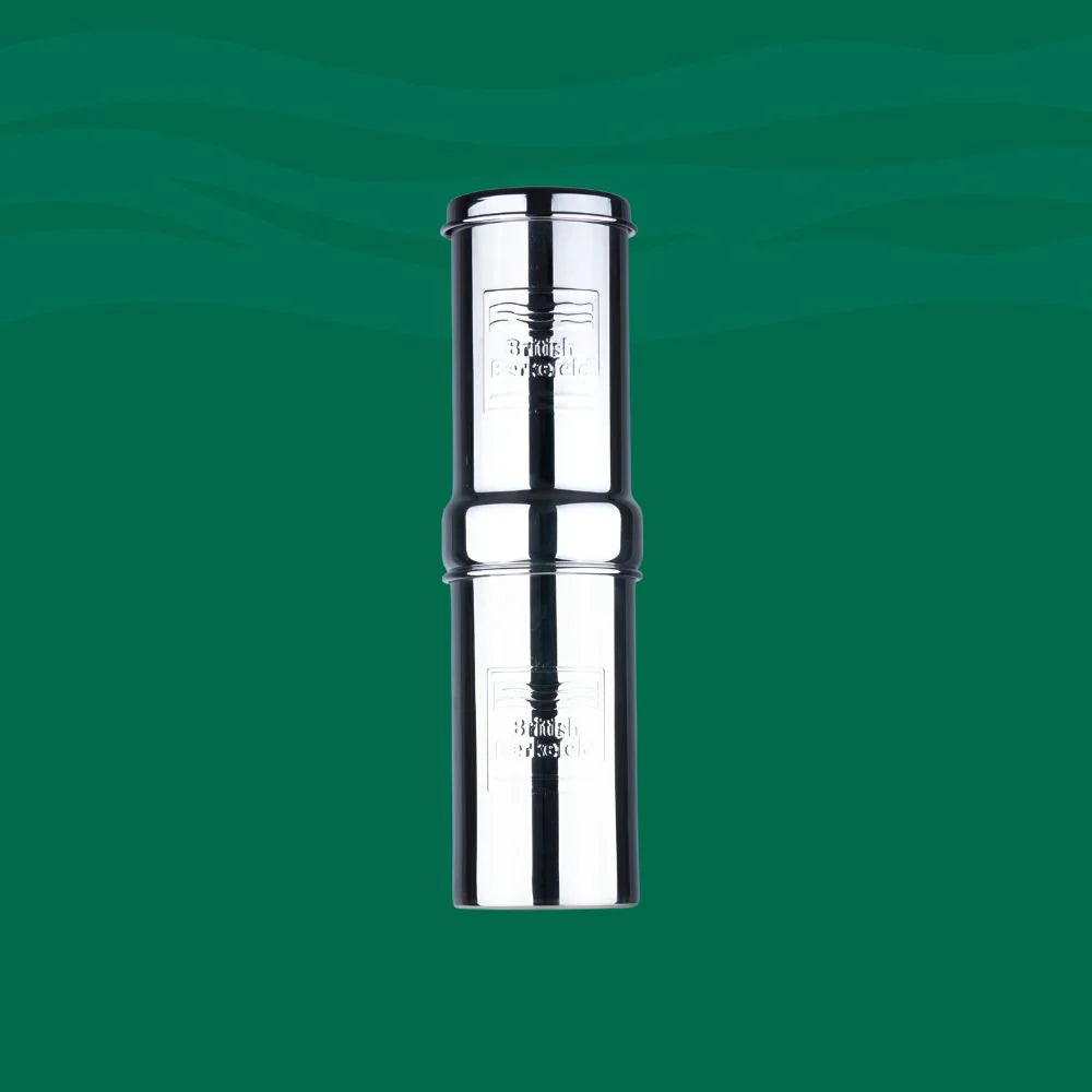 A shiny British Berkefeld 1-liter stainless steel gravity system by American Reserves stands against a green backdrop, featuring a cylindrical design and branding. It uses an Ultra Sterasyl ceramic filter for effective purification.