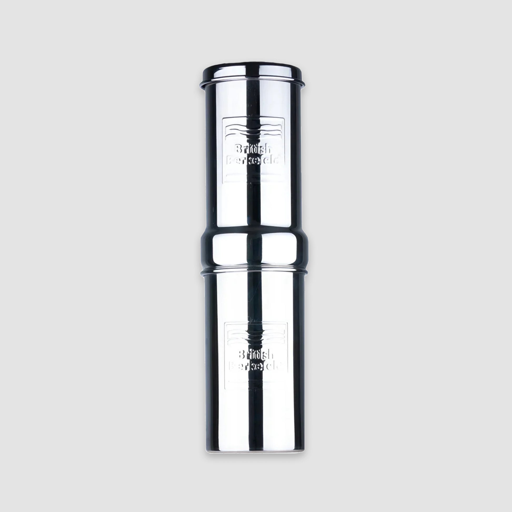 The American Reserves British Berkefeld 1 Liter Stainless Steel Gravity System boasts a sleek design with embossed branding, featuring two stacked cylinders and an Ultra Sterasyl ceramic filter for superior water purification.
