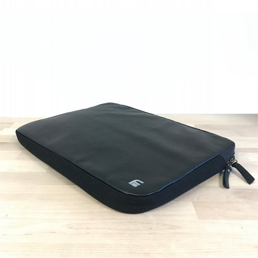 American Reserves PU Leather Large Privacy Protection Laptop Sleeve (9 x 13.5) is a sleek, black sleeve with a zipper, resting on a light wooden surface, designed to keep your device safe and secure.