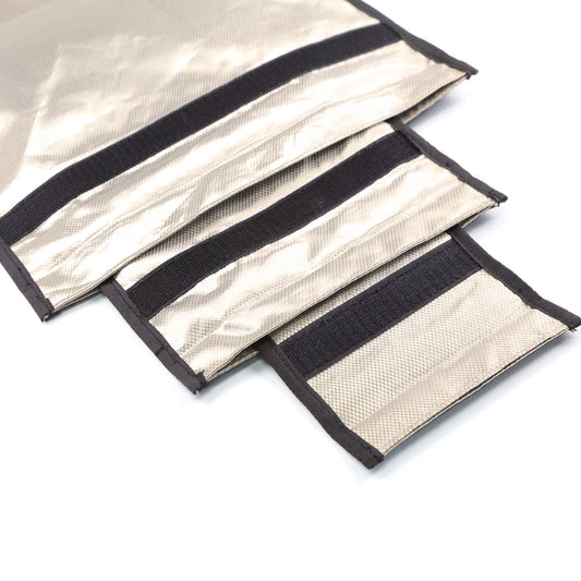 Close-up of three overlapping metallic silver and black Velcro straps on a white background, similar to the sleek design found in American Reserves Triple Layer CYBER Fabric Faraday Bags Kit (3 pack small) for EMF protection and signal blocking.