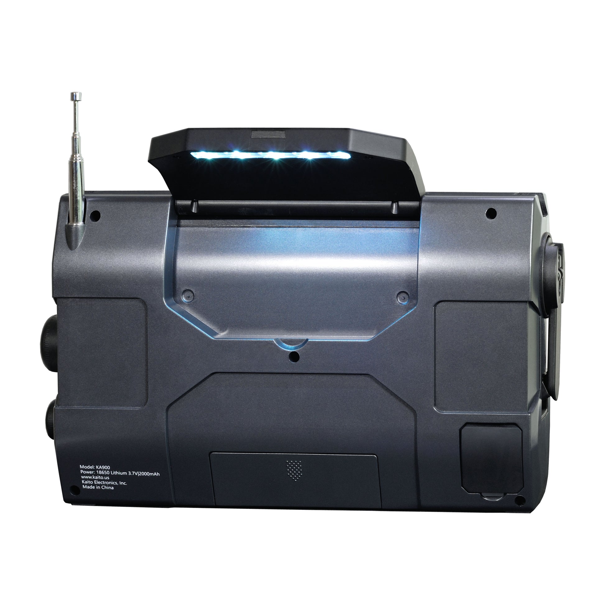 The Kaito Emergency Radio Voyager Max KA900 by American Reserves is a sleek, black portable receiver with LED-lit panel. It features a left-side antenna and right-side control knobs, ideal for emergencies. Specifications are noted on the bottom label.