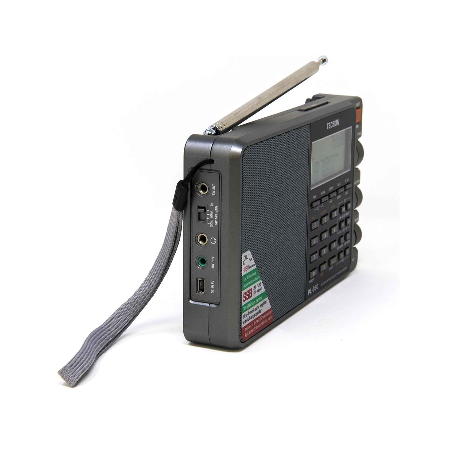 The Tecsun PL880 by American Reserves is a portable radio with a dynamic audio amplifier, world band receiver, extended antenna, digital display, control buttons, gray strap, and various side input/output ports.