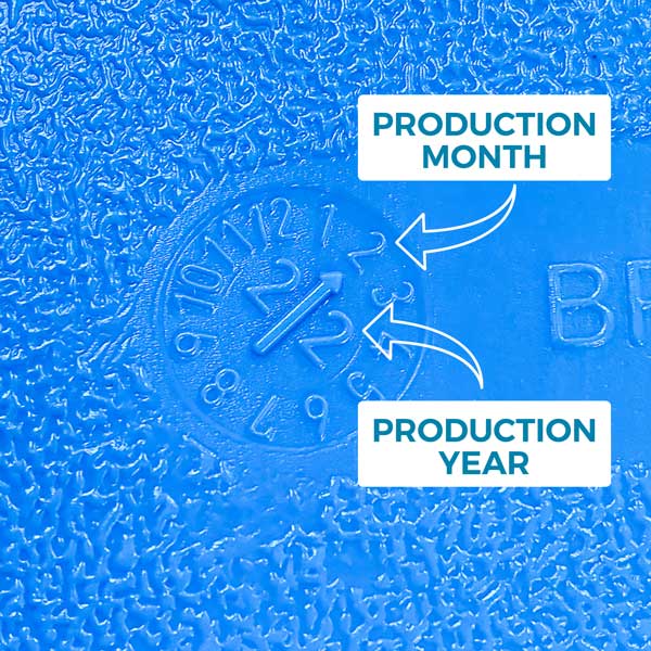 Close-up of a blue plastic surface on an AquaBrick 2 Pack Food and Water Storage Container by American Reserves, showing embossed numbers for production month (2) and year (23), highlighted by arrows.
