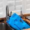 The AquaBrick 6 Pack, by American Reserves, is filled from a kitchen faucet in a sink set against a brown countertop. These large blue containers are perfect for water storage.