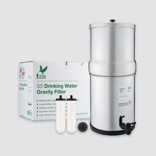 A British Berkefeld Doulton 3.17 Gallon Countertop Gravity-Fed Water Filtration System with two Ultra Sterasyl ceramic filter candles and a packaging box in the background, featuring the American Reserves brand.