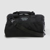 The black CORDURA® Utility Bag Medium by American Reserves, featuring a shoulder strap and a rectangular front label, serves as both a sleek duffel bag and a Faraday pouch for signal blocking. Its showcased on a plain gray background.