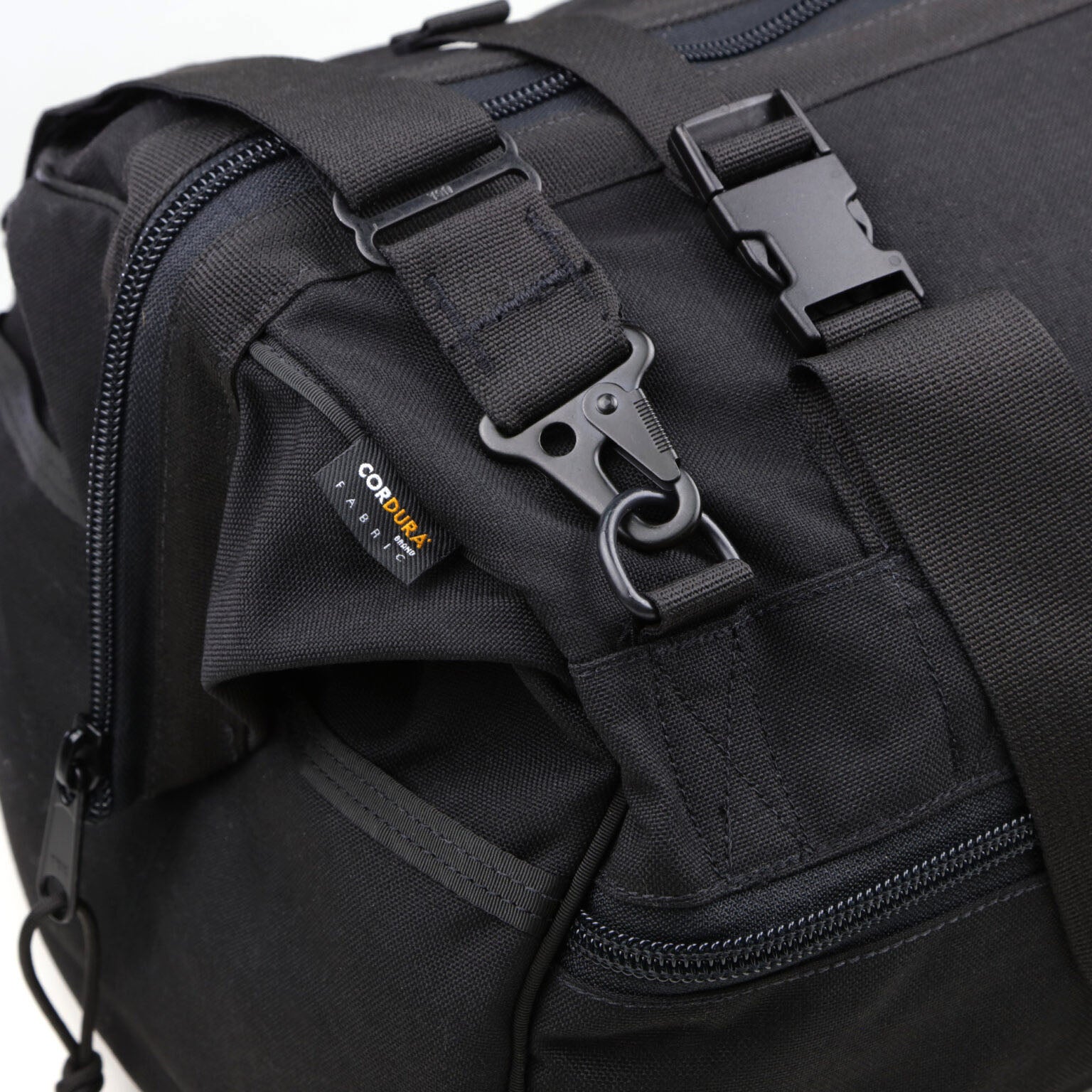 Close-up of a black American Reserves CORDURA® Utility Bag Large featuring heavy-duty buckles and zippers. The visible label indicates its durable fabric, ideal for anyone looking for reliability and style.