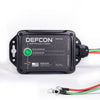 The DEFCON™ Vehicle + EMP Vehicle Protection Kit by American Reserves is a black rectangular system that protects against electromagnetic pulses, featuring a green indicator light with red and green wires.