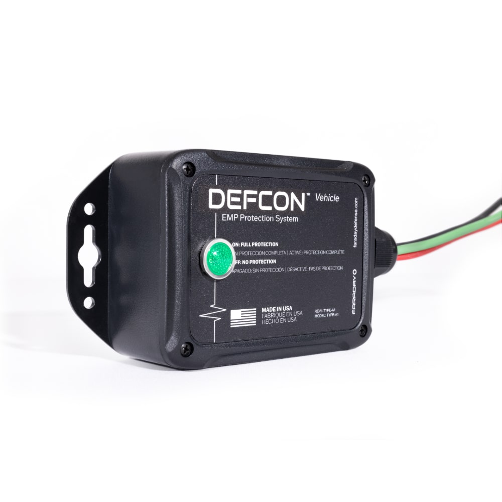 A black electronic device labeled DEFCON™ Vehicle + EMP Vehicle Protection Kit by American Reserves, with attached wires, is set against a white background. This product offers protection against electromagnetic pulse threats for vehicles.