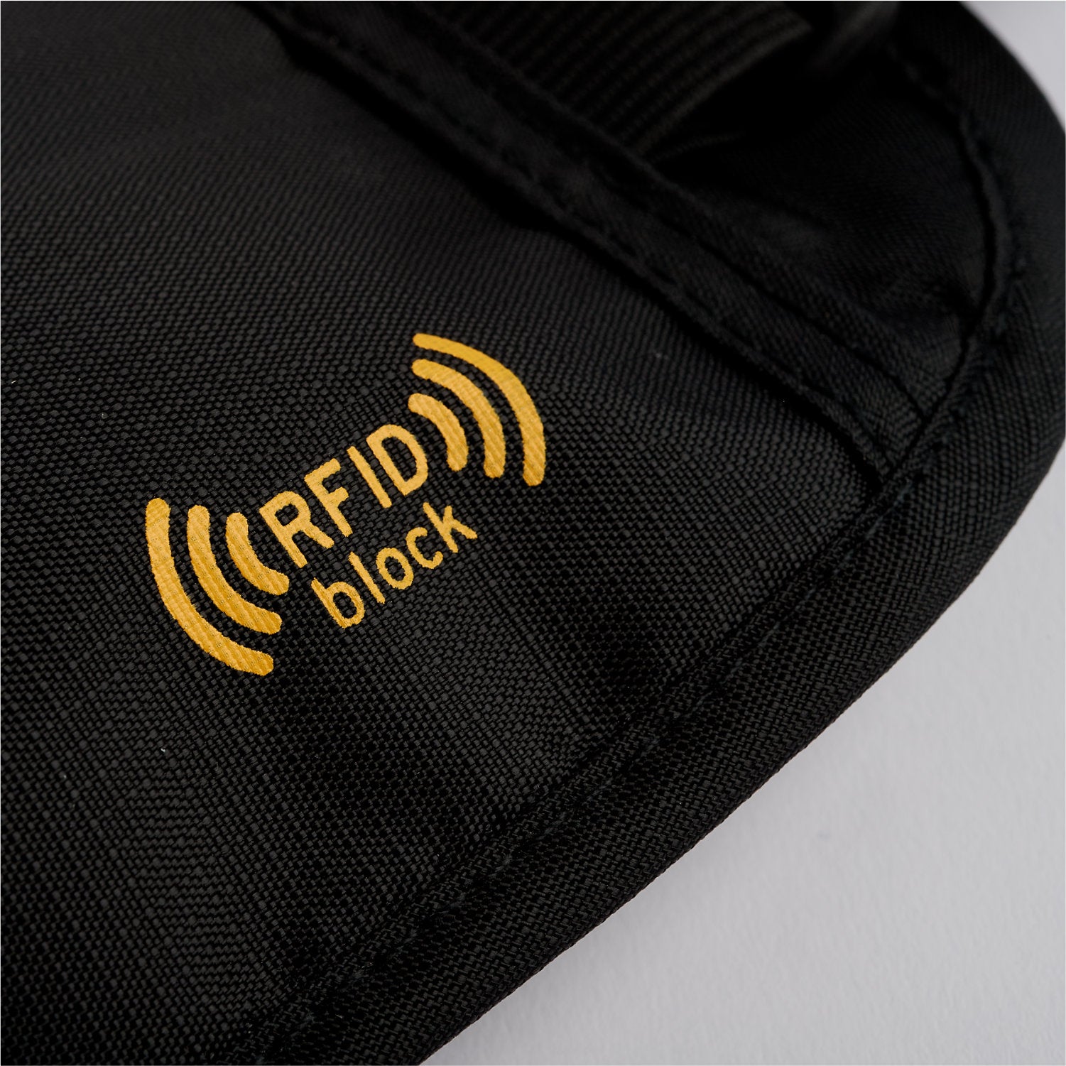 Close-up of a black fabric on the American Reserves Faraday Waist Pack – RFID Belt Bag, showcasing a yellow RFID block logo indicating radio frequency identification protection.