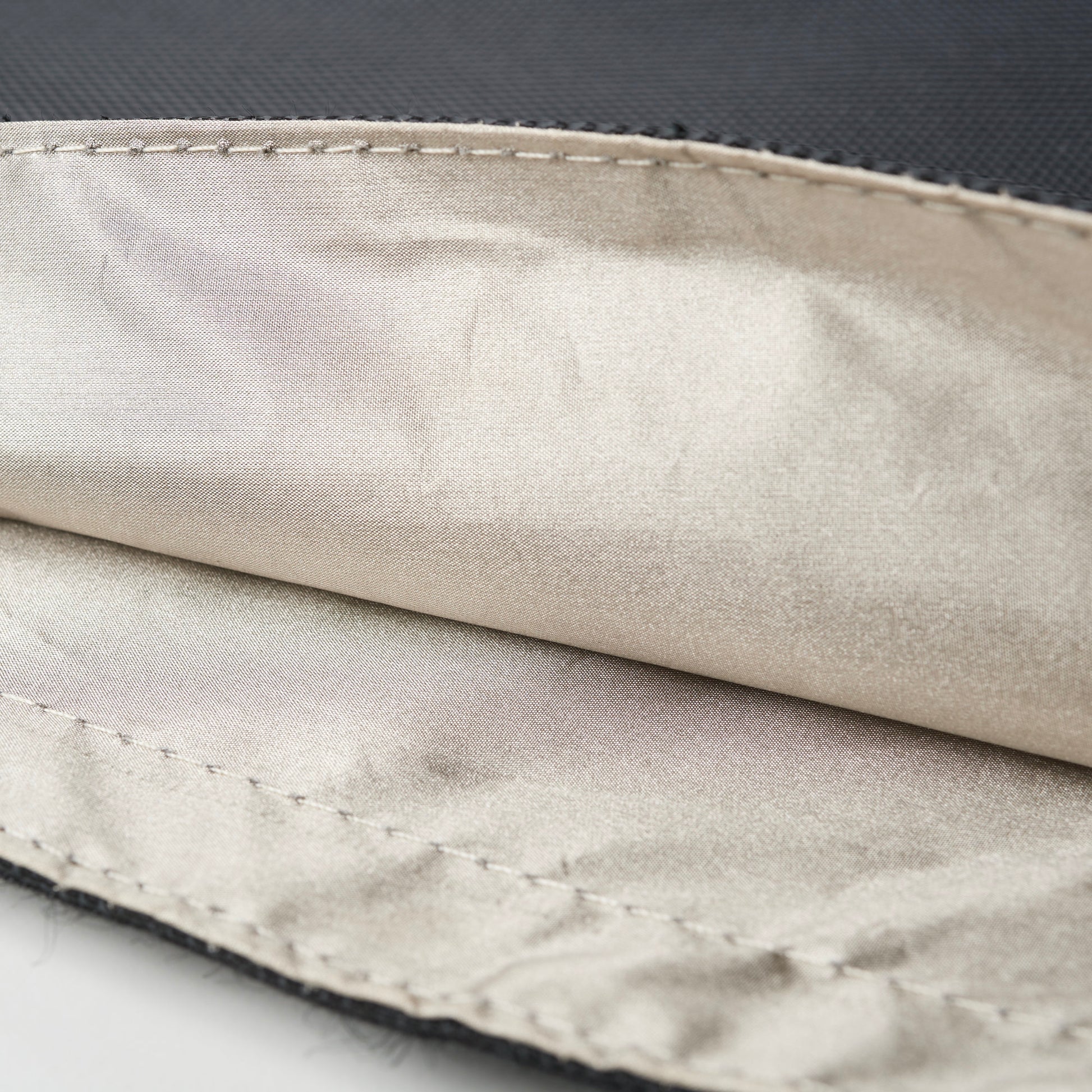 Close-up view of an XXL Forensic Faraday Laptop Jacket (14 x 16) by American Reserves, featuring a black zippered fabric case with a beige satin-like RFID-blocking lining.