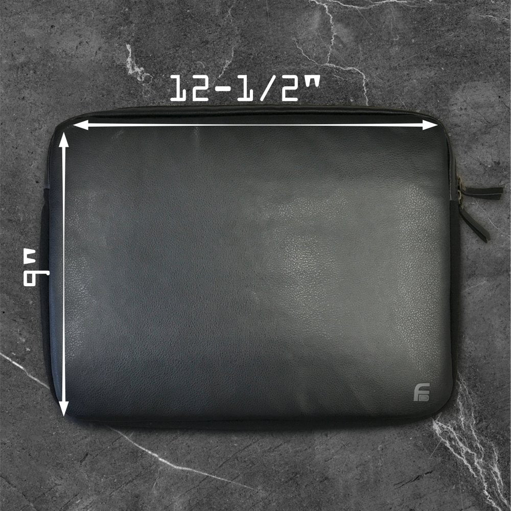 The American Reserves PU Leather Large Privacy Protection Laptop Sleeve rests on a dark gray marble surface. Measuring 9 x 13.5, this black sleeve enhances privacy with its elegant design and discreetly fits into any setting.