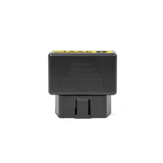 The American Reserves EMP Vehicle Protection, a black electronic diagnostic device featuring a yellow label, fits snugly into an OBD2 port for automotive use and is showcased against a white background.